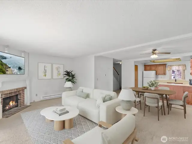 The open-concept living and dining area is anchored by a cozy corner fireplace—perfect for curling up on cool Pacific Northwest evenings.