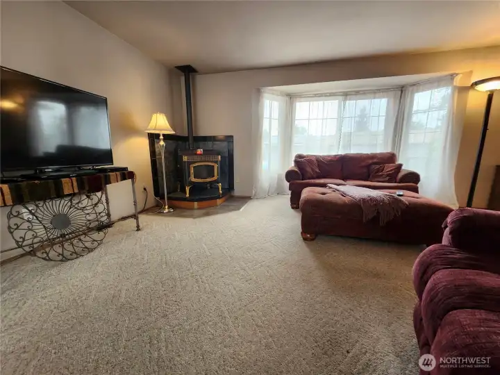 Large recessed window in living room brings in light & landscaping beauty