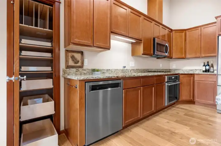 An inviting kitchen boasts a gas stove and custom cabinets with pull-out drawers for easy access.