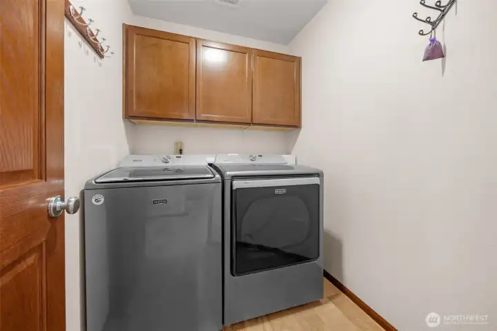 The laundry room is equipped with storage and Maytag washer and dryer.
