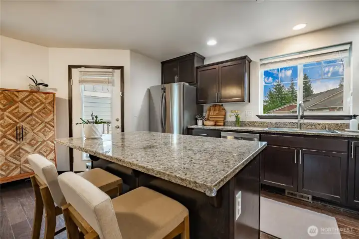 Spacious Granite Island and door leading to deck and backyard