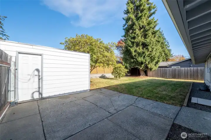 Fully fenced private back yard features a large storage shed.