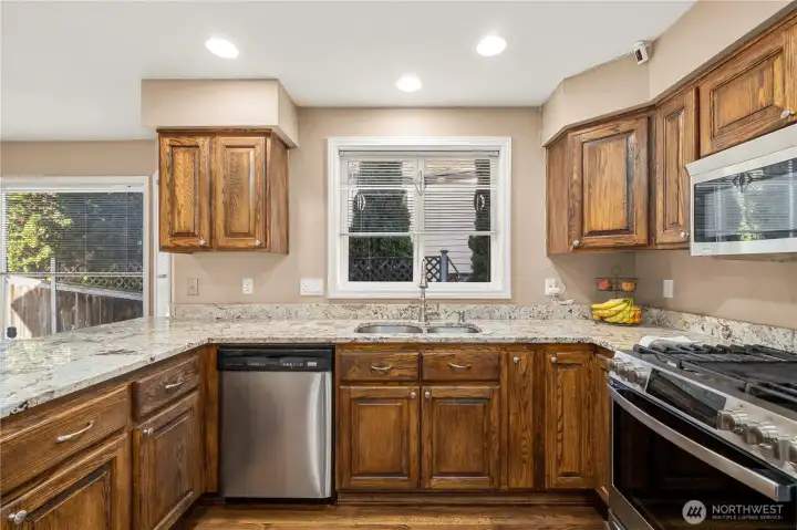Ample counterspace on granite countertops and solid wood cabinetry