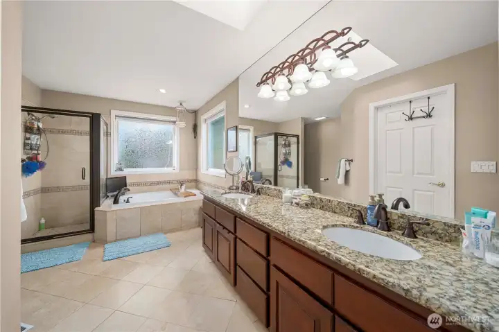 Huge primary suite bathroom w/double sinks on granite
