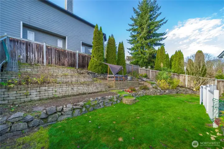 3 tiered garden bursting with fresh herbs, vegetables, and fruit