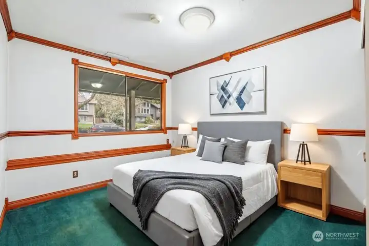 [Photo is virtually staged.] Private bedroom tucked away downstairs. Ideal for guests or multigenerational living. Excellent work from home flexibility too.