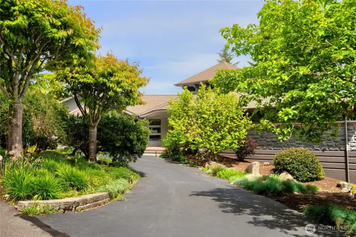 Lush landscaping surrounds entry and creates a natural privacy buffer