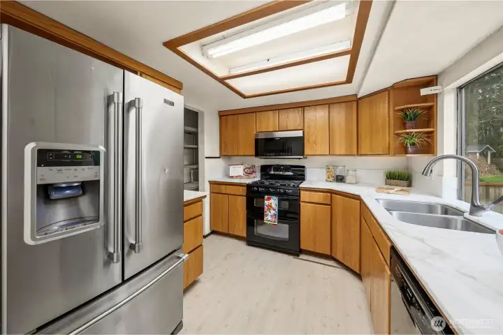 Efficient kitchen has a gas oven and gorgeous marble counters. All appliances stay! Large window overlooks the backyard.