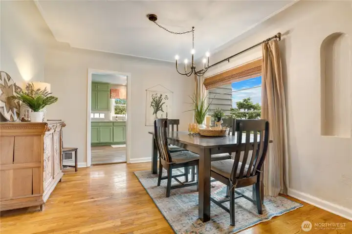 Light fills this dining space, where elegant coved ceilings, a designer light fixture, and a charming wall niche create a setting well suited for everyday meals or intimate gatherings.