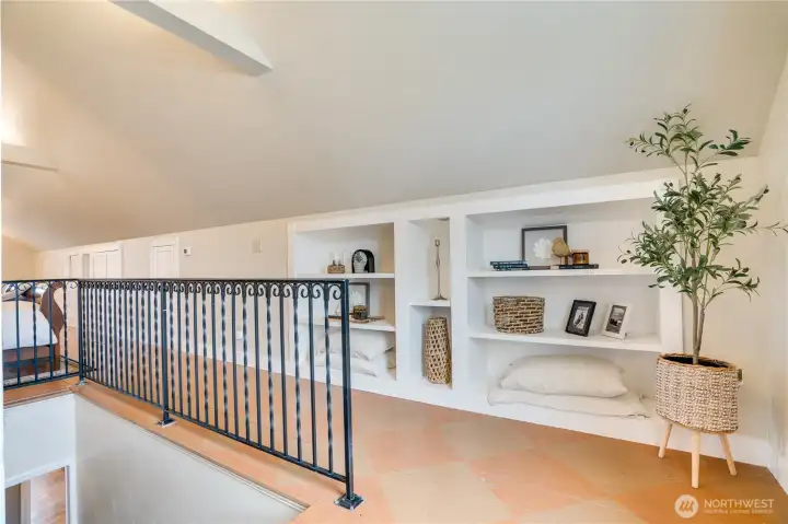 As you ascend into the private primary retreat, built-in shelving adds both character and functionality—ideal for display, storage, or a personal library feel.
