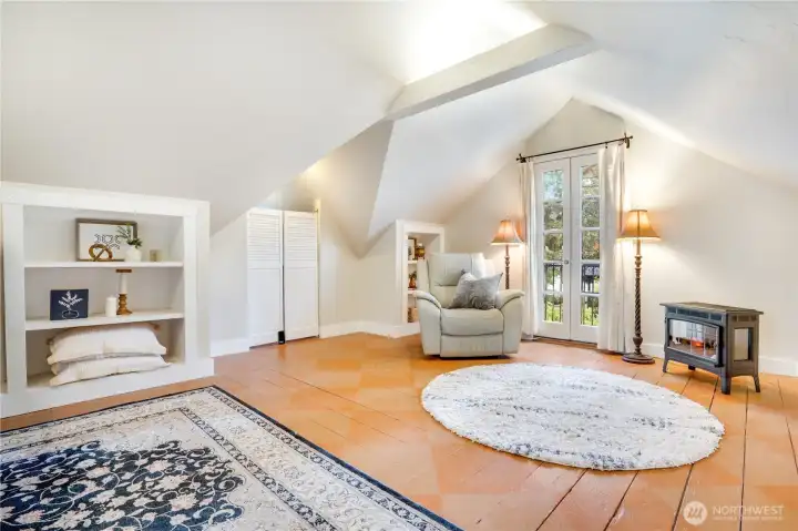 French doors open to a wrought iron balcony, while a new electric fireplace adds warmth and ambiance. A generous walk-in closet is tucked just beyond.