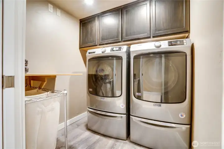 This dedicated utility room includes a second laundry area with commercial-grade Maytag appliances and overhead storage, adding everyday practicality and convenience.