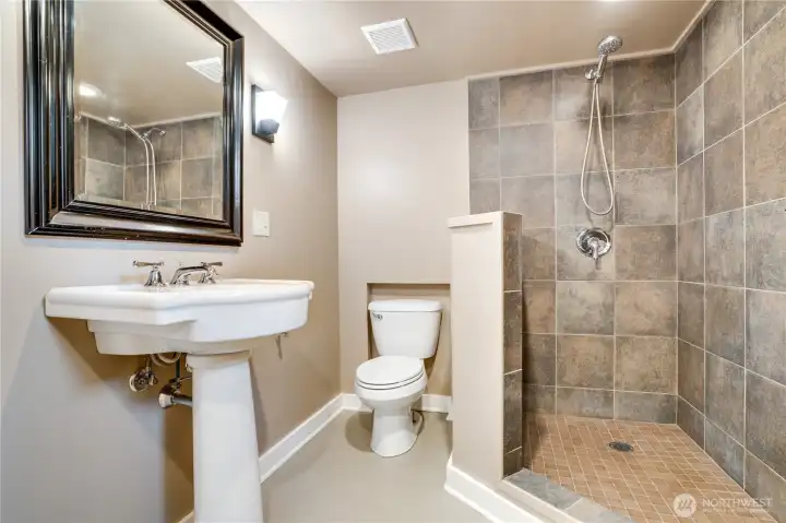 A clean, modern three-quarter bath with a walk-in shower offers comfort and convenience for longer stays or separate living.