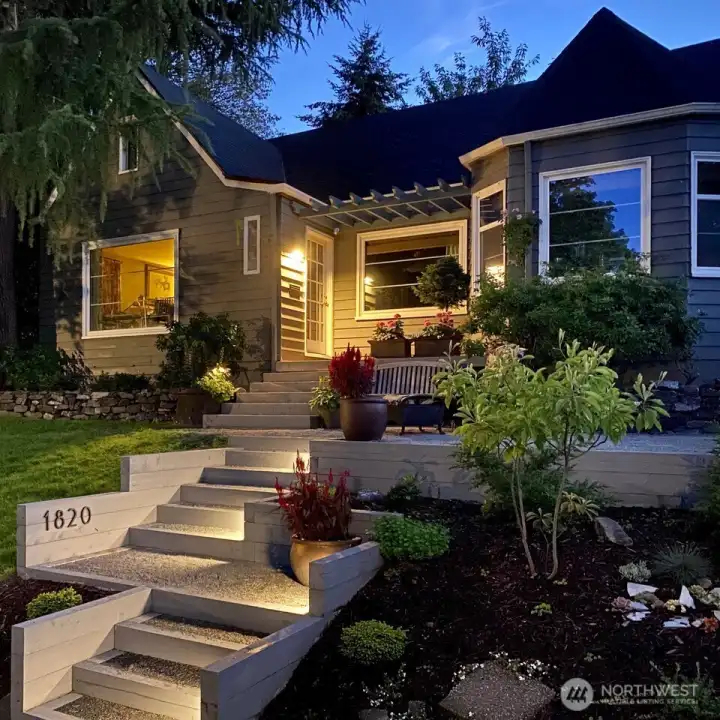 As the day winds down, landscape lighting highlights the beautifully maintained grounds—just moments from campus, neighborhood schools, and the vibrant Proctor District. Thanks for visiting! Photo provided by owner to illustrate seasonal landscaping as it matures and blooms.