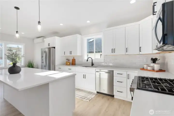 Stainless steel appliances and a gas cooktop.