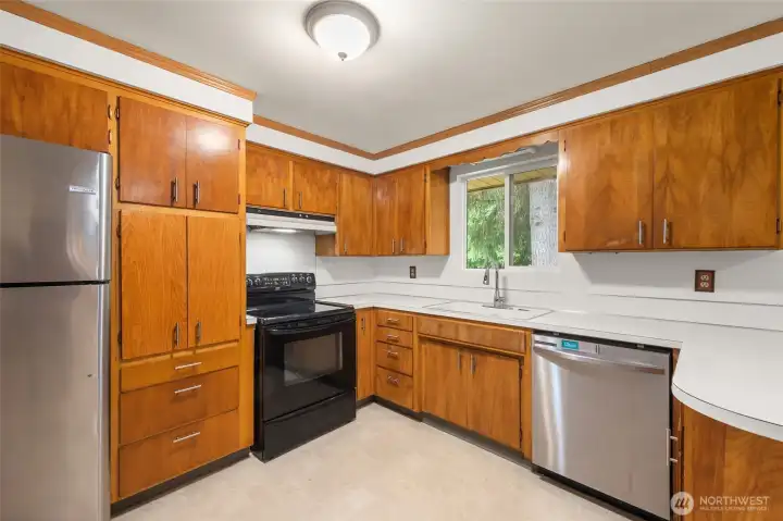 Bright kitchen featuring stainless steel appliances and plenty of workspace.