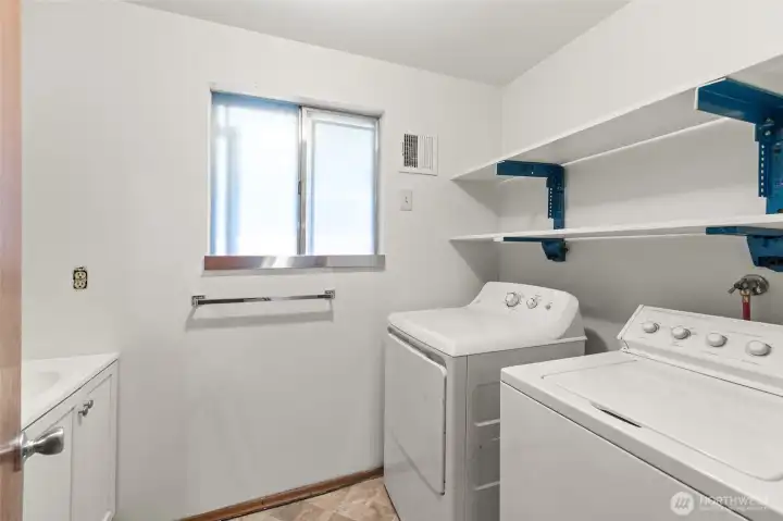 Convenient laundry room with extra space for storage and organization, includes half bath.