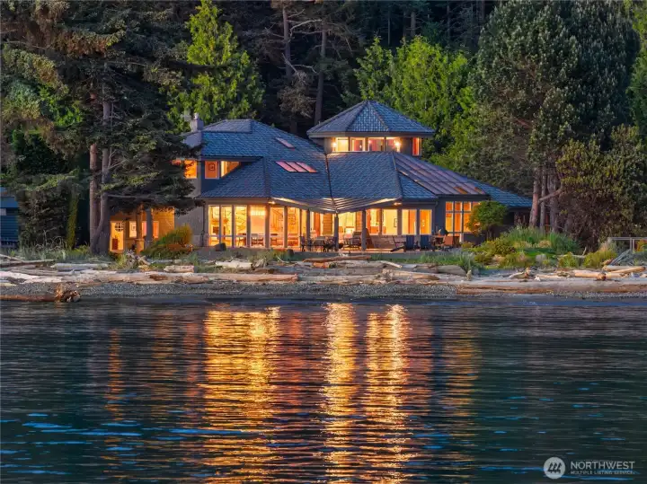 Experience the magic of waterfront living in this extraordinary private estate, where walls of glass, glowing interiors, and tranquil shoreline views create an unforgettable Pacific Northwest retreat.