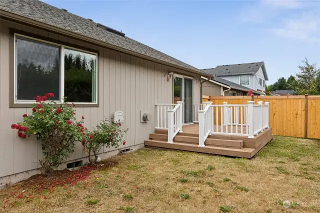 The raised back deck offers a great barbeque spot, and leads down to a level yard with rose bushes.