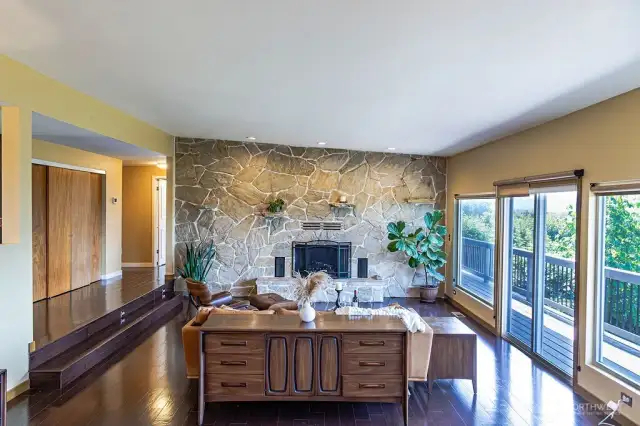 Gleaming engineered hardwood floors throughout main floor. Grand stone wall accentuates the wood burning fireplace.