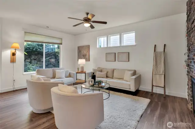 A light and bright family room has a large picture window accentuating the outdoor landscape.