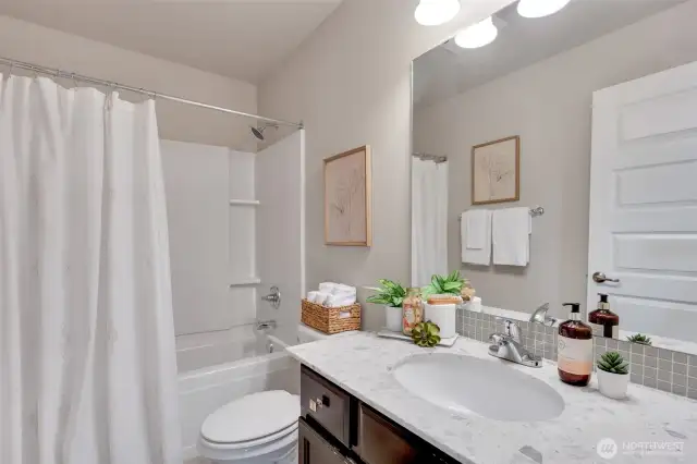 A divine full bath services bedrooms two and three.