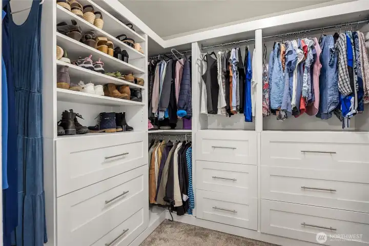 Owner installed this fantastic walk in closet with lots of hanging space and drawers.