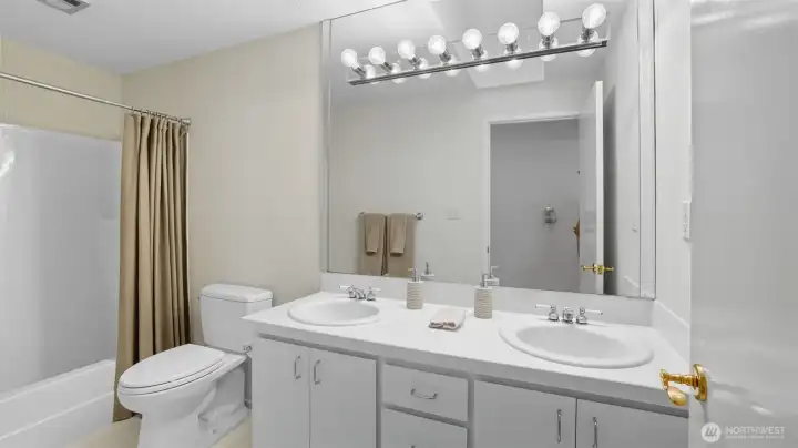 Convenient full bath with double vanity and a combination tub/shower.