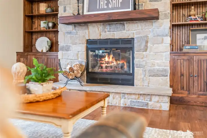 This wood burning fireplace flanked by built-in bookshelves helps complete the lodge-like ambiance of this gorgeous main-floor living room.