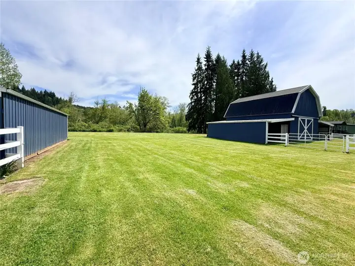 Standing in between the shop and the barn.