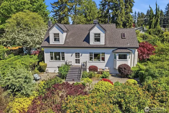 The English cottage vibe you've dreamed of awaits in this gardener's paradise on a lush .4-acre lot that you truly must see to believe!