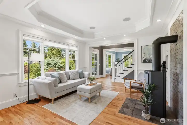 The family room with tray ceilings is bright and inviting, yet cozy and comfortable thanks to an efficient wood stove.