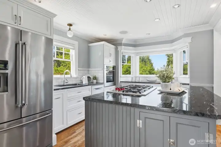 High-end Wolf appliances, gas cooking, custom cabinets, a coffee station & smart storage in the kitchen will wow any chef.