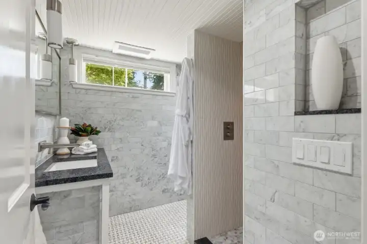 Beautifully remodeled 3/4 bathroom on the lower level comes equipped with a rain shower and stylish lighted niche.