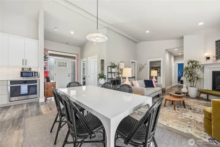 Bright open-concept living and dining space with vaulted ceilings, LVP flooring, propane fireplace, and seamless flow perfect for entertaining or everyday living.