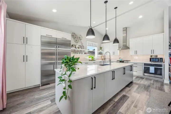 Luxury kitchen with oversized island, quartz countertops, under-cabinet lighting, pull-out pantry storage, and premium appliance package.