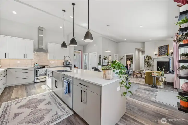 Beautiful entertainer’s kitchen featuring double full-size ovens, propane cooktop, quartz surfaces, open shelving, and stylish backsplash details.