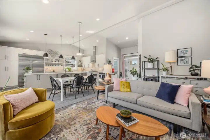 Inviting living room with vaulted ceilings, updated fixtures, propane fireplace, and large windows bringing in abundant natural light.