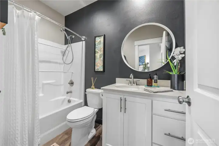 Stylish main bathroom with quartz counters, upgraded fixtures, and beautifully finished tub surround offering a clean modern design.