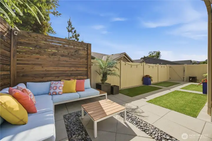Low-maintenance artificial turf and professionally designed landscaping create year-round beauty and functional outdoor living space.
