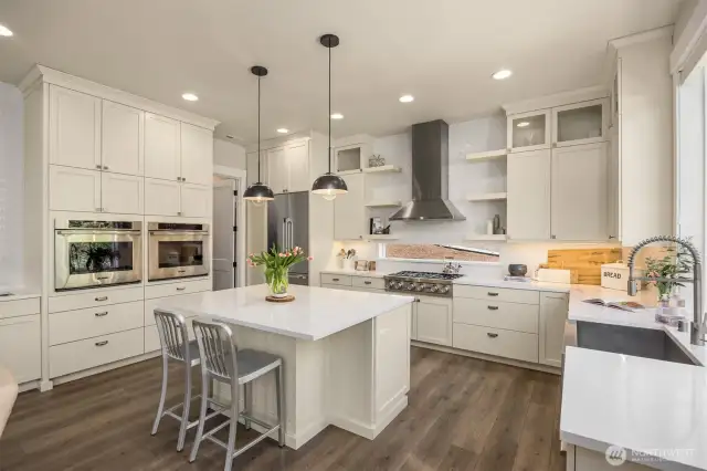 Dual ovens, floating shelves, and a wet bar are all in this amazing kitchen.
