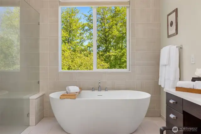 The lovely soaking tub overlook the back green space.