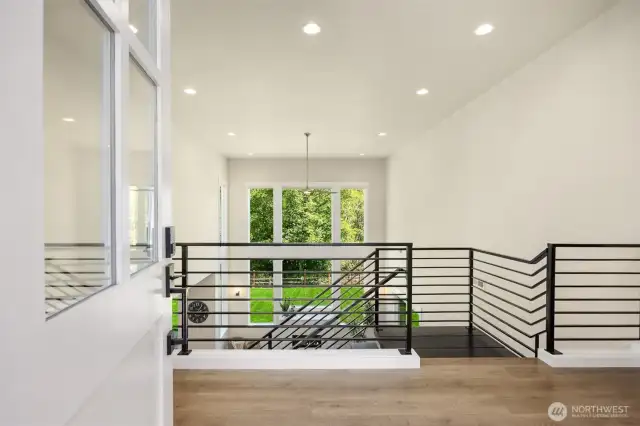 An impressive entryway opens up to tall ceilings and a wall-of-windows.