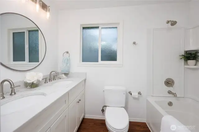 Full hall bathroom with dual vanity.