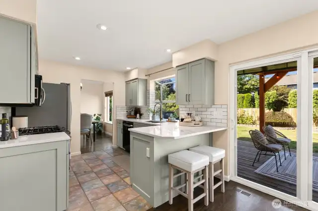 This sunny kitchen offers breakfast bar and views of backyard.