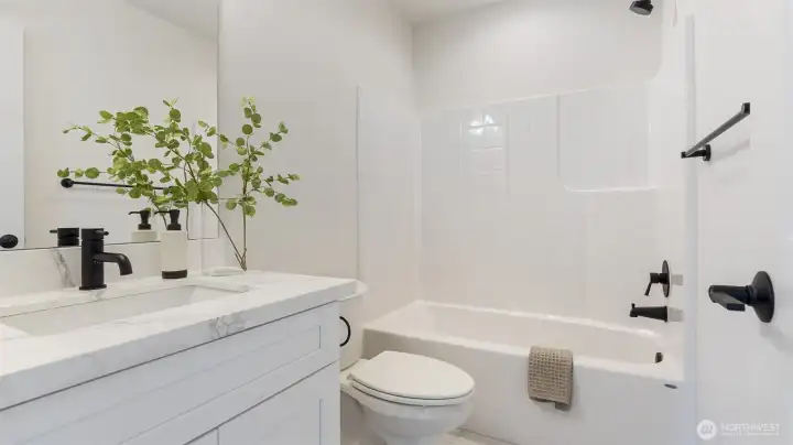 Main Bath has quartz counter, undermount sink and tile flooring.