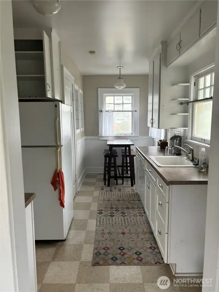 Large, open upper kitchen with windowed breakfast nook and ample cabinets and storage.