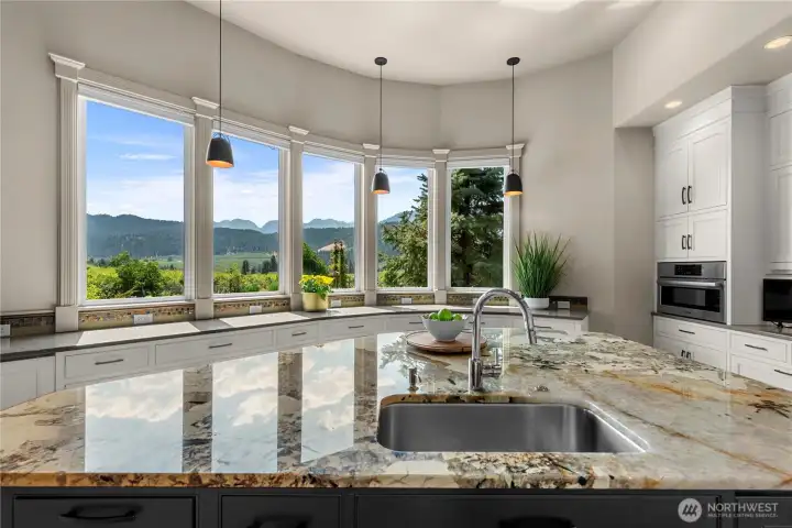 Spacious kitchen with a statement island and panoramic windows, perfectly positioned to enjoy picturesque valley and mountain views while cooking or entertaining.