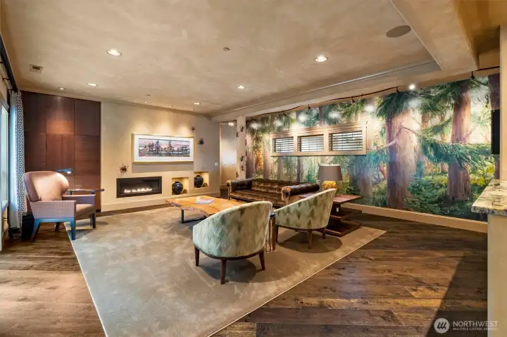 A true focal point of the home, the custom mural by local artist Jennifer Bowman brings the surrounding forest indoors, layered with rich texture and nearly thirty shades of green.