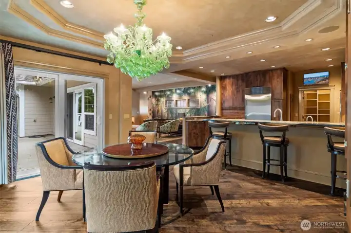 A Murano glass chandelier serves as a striking focal point, known for its handcrafted artistry and timeless Italian design.